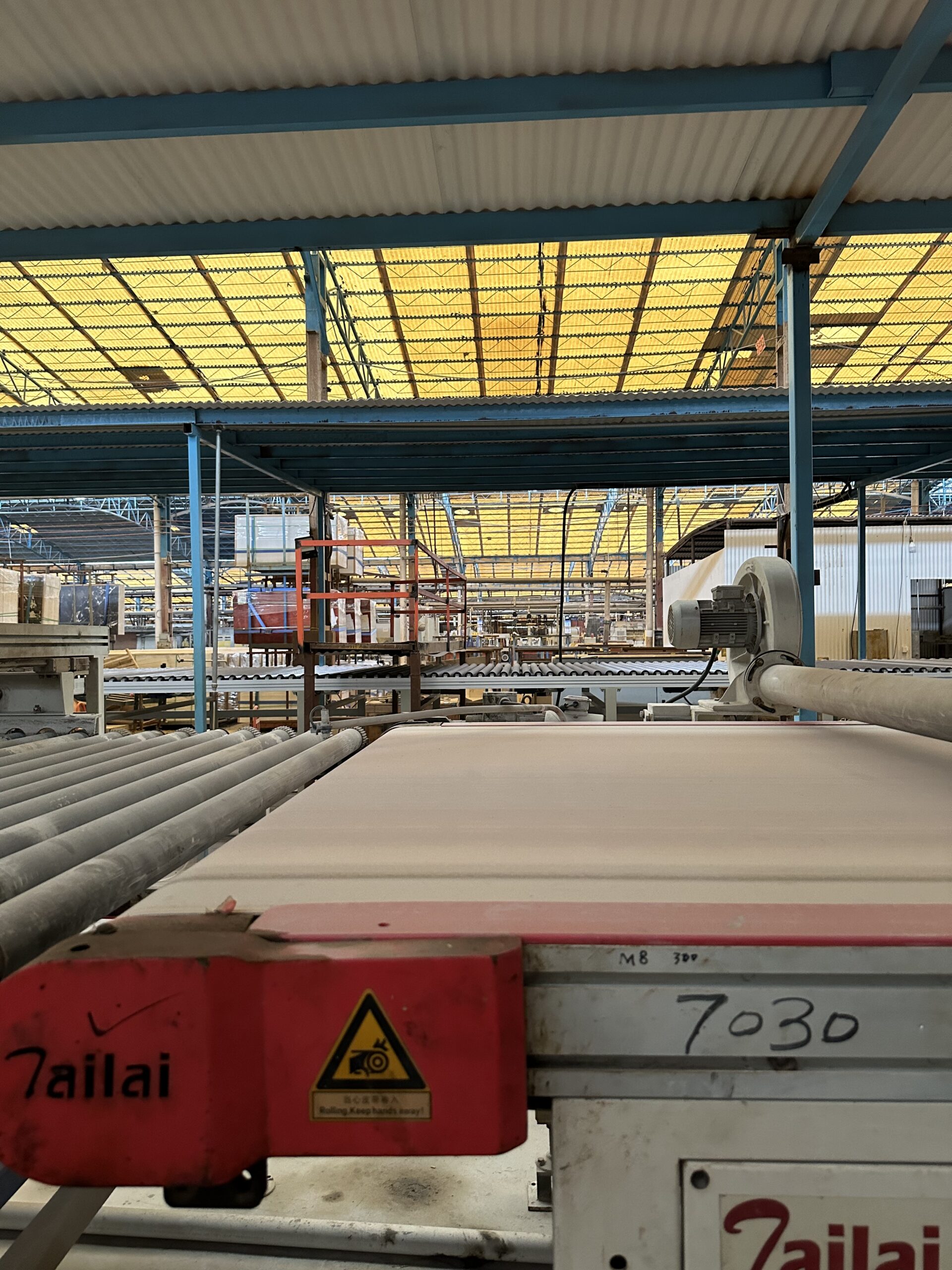 Press machine forming sintered stone slabs for hospitality projects